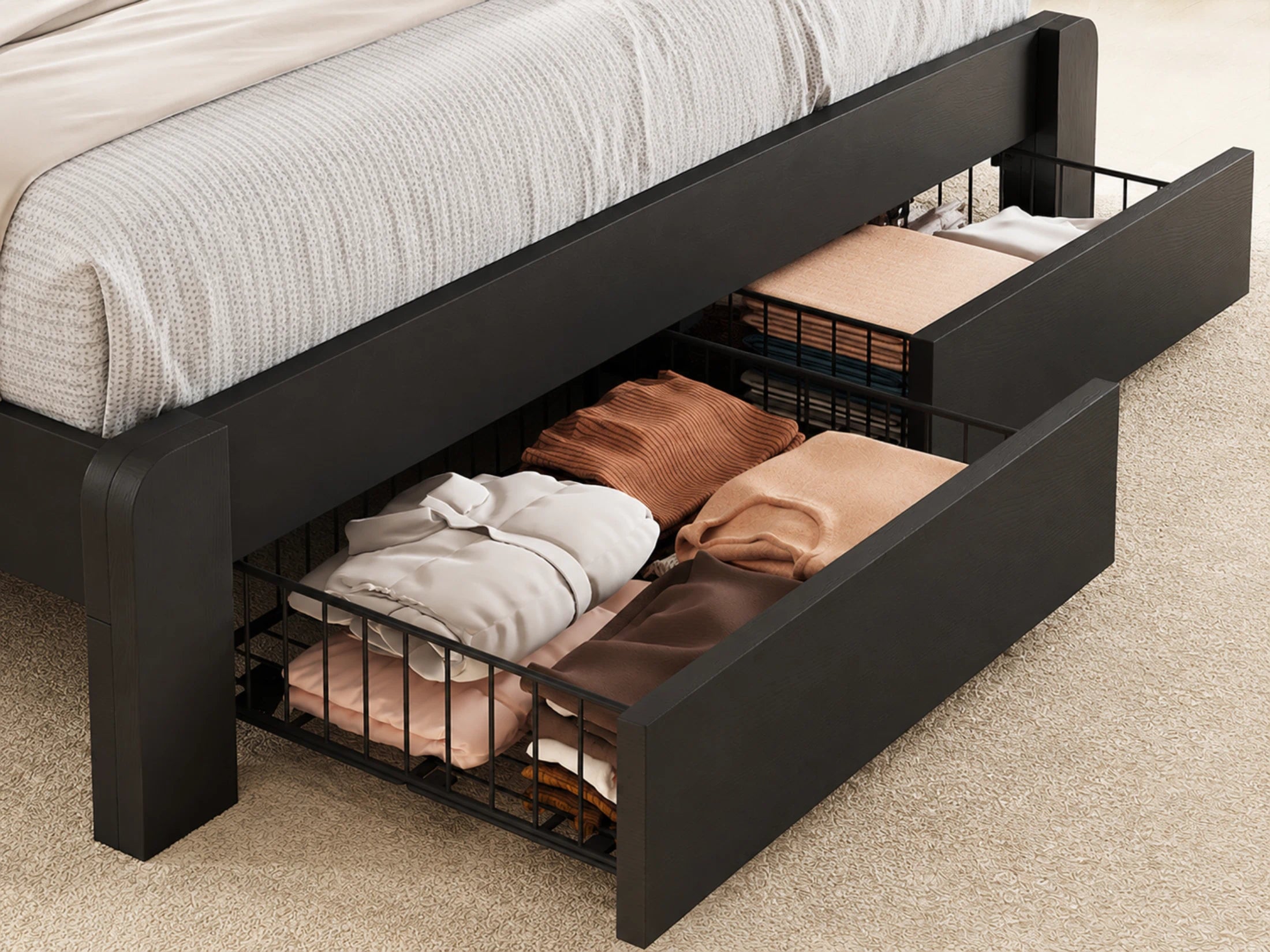Black bed frame with open drawers containing folded clothes on a carpeted floor.