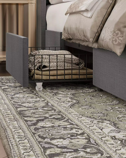 Gray upholstered bed frame with a metal basket and patterned rug in a bedroom setting