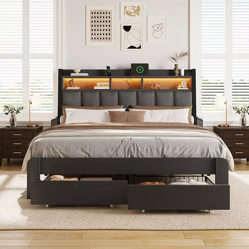 Bedroom with a black bed frame featuring storage drawers, wooden flooring, and white walls.