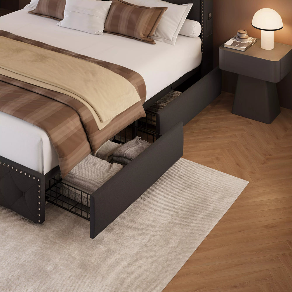 Bedroom with a bed that has storage drawers open, revealing pillows and blankets.