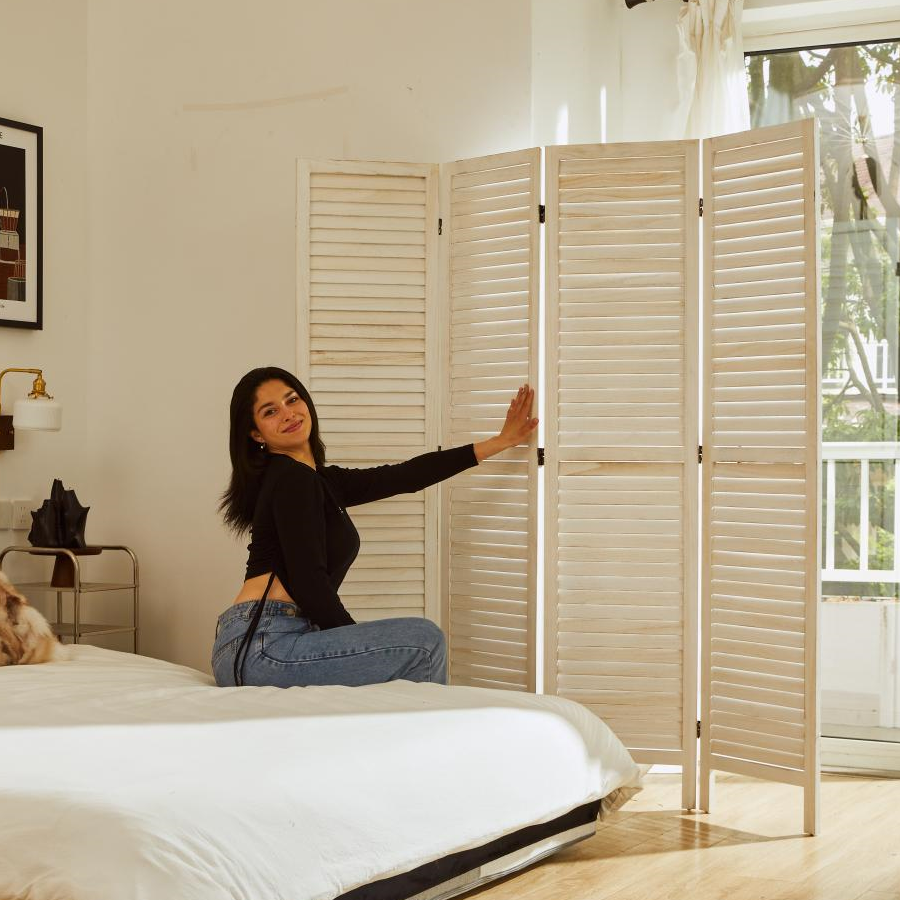 White wooden folding partition screen separating living room space from dining area.
